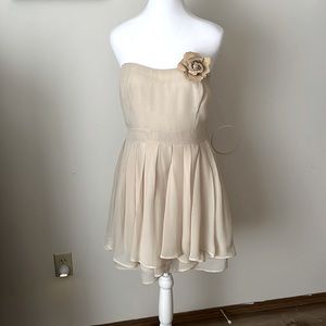Nude colored mini dress. Outer layer supported by 100% polyester lining.